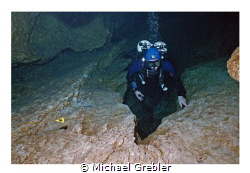 My dive buddy pauses above the "chimney" as we work our w... by Michael Grebler 